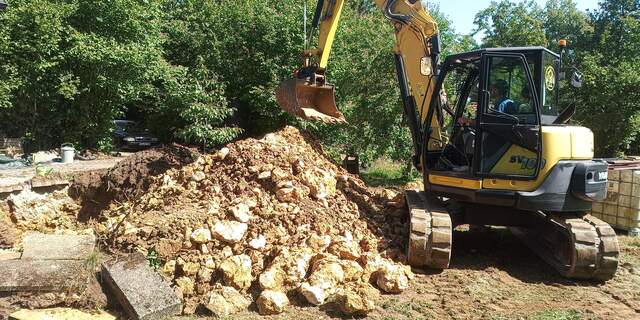 Bagger hebt Fels- und Erdmaterial aus